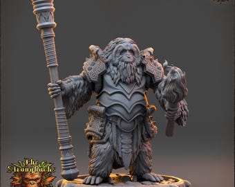 Könnte beinhalten: Graue Miniaturfigur eines Primatenkriegers, der einen Stab und eine Fackel hält. Die Figur ist mit Rüstung bekleidet und steht auf einem mit Totenköpfen verzierten Sockel. Das Daybreak Miniatures Logo ist sichtbar.