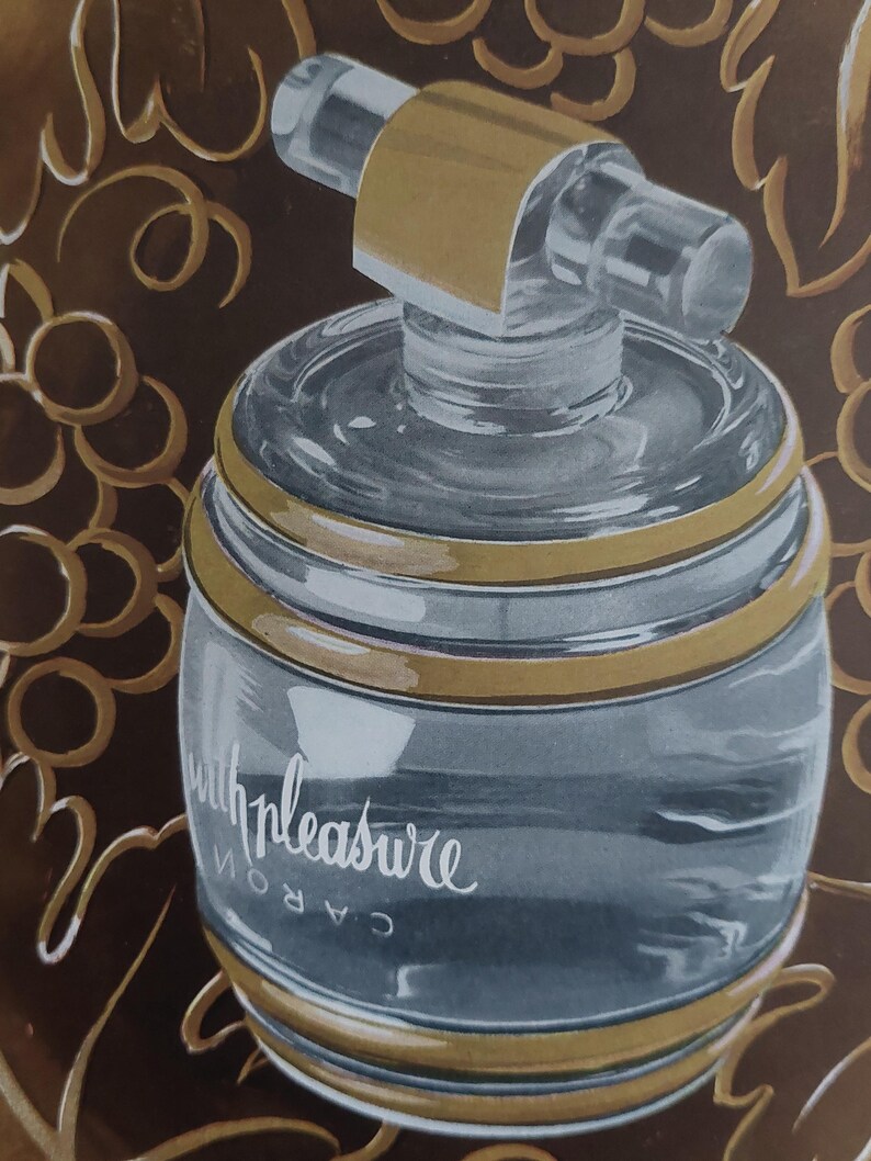 Puede incluir: Un frasco de perfume vintage con un cuerpo de vidrio transparente y una banda dorada alrededor de la parte superior e inferior. El frasco tiene un pulverizador cil&iacute;ndrico transparente y est&aacute; etiquetado "with pleasure" en cursiva. El fondo es marr&oacute;n oscuro con dise&ntilde;os de vid dorados.