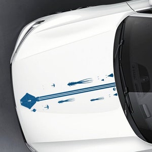 May include: A white car with a blue and white graphic decal on the bonnet. The decal features a stylised design with lines and geometric shapes. The text "Ghost & Phantom!" is visible at the top of the image.