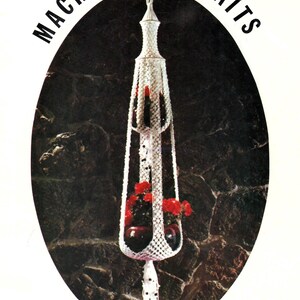 May include: A white macrame plant holder with red flowers in a dark glass pot. The text "MACRAME PORTRAITS" is at the top, and "ANGEL FLAKE" is at the bottom.