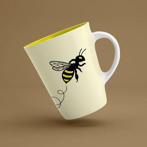 May include: A light yellow ceramic mug featuring a graphic of a black and yellow bee in flight. The bee is positioned above a dashed, swirling black line representing its flight path. The mug has a white handle and a bright yellow interior.