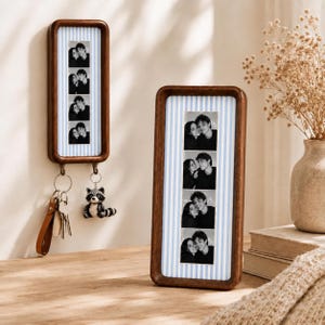 Puede incluir: Dos marcos rectangulares de madera con esquinas redondeadas, con un fondo de rayas verticales en azul claro y blanco. Cada marco muestra una tira vertical de cuatro fotos en blanco y negro de una pareja. El marco izquierdo tiene dos ganchos.