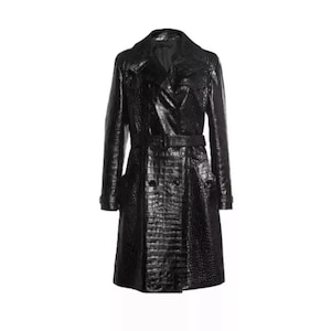 Könnte beinhalten: Ein schwarzer, langer Trenchcoat mit einem strukturierten, krokodilartigen Muster. Der Mantel hat einen doppelreihigen Verschluss, einen Gürtel in der Taille und einen klassischen Kragen. Der Mantel ist ein stilvolles Oberbekleidungsstück.