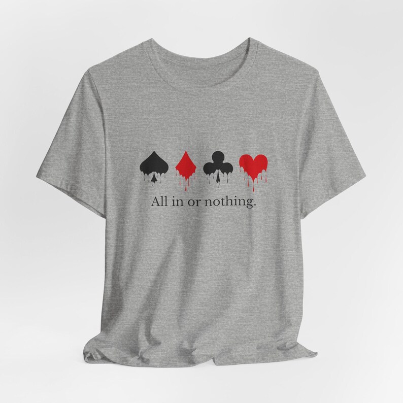 K&ouml;nnte beinhalten: Graues T-Shirt mit Spielkartensymbolen: Pik, Karo, Kreuz und Herz, mit roten Tropfeffekten. Der Text "All in or nothing" steht darunter. Das T-Shirt ist aus weichem Material.