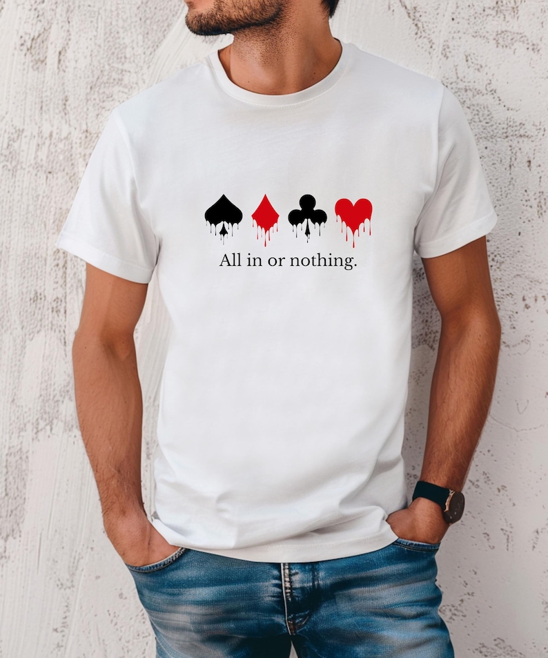K&ouml;nnte beinhalten: Wei&szlig;es T-Shirt mit vier Spielkartensymbolen in Schwarz und Rot mit einem Tropfeffekt. Der Text "All in or nothing" ist darunter gedruckt. Das T-Shirt hat einen Rundhalsausschnitt.