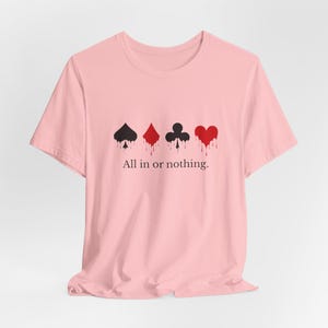 K&ouml;nnte beinhalten: Hellrosa T-Shirt mit vier Spielkartenfarben: Pik, Karo, Kreuz und Herz, jeweils mit einem tropfenden Bluteffekt. Der Text "All in or nothing" ist darunter gedruckt.