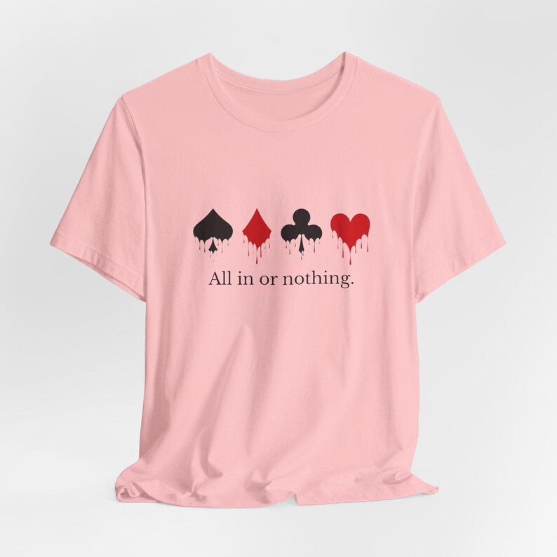 K&ouml;nnte beinhalten: Hellrosa T-Shirt mit vier Spielkartenfarben: Pik, Karo, Kreuz und Herz, jeweils mit einem tropfenden Bluteffekt. Der Text "All in or nothing" ist darunter gedruckt.