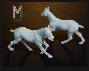 May include: Two white miniature horse figurines in a dynamic pose, one in front of the other. The figurines are detailed and appear to be running. The text "M" and "Max miniatures" is in the upper left corner.
