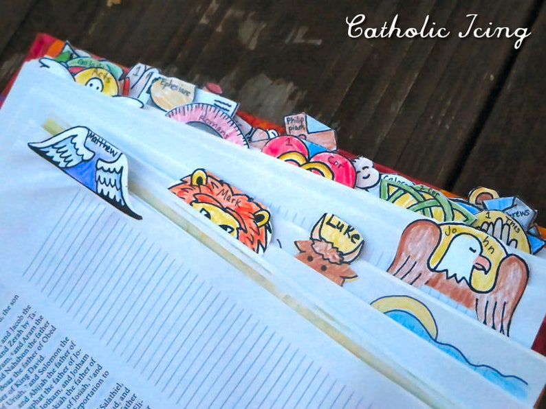 May include: A close-up of a Bible with colorful paper bookmarks. The bookmarks feature illustrations of animals and angels, with names like Matthew, Luke, and John.