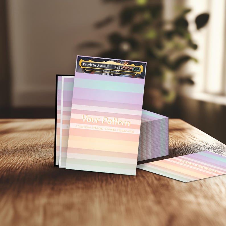 Puede incluir: Fundas de cartas personalizadas con un dise&ntilde;o de rayas de arco&iacute;ris pastel. El texto "Your Pattern" est&aacute; impreso en la parte delantera. La funda superior presenta el texto "Vaevictis Asmadi". Las fundas se muestran sobre una superficie de madera.