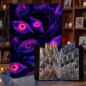 Peut inclure: Un classeur de cartes noir avec une fermeture éclair et une sangle de transport noire. La couverture du classeur présente un motif répété d'yeux roses et violets brillants sur fond noir. Le classeur est ouvert, révélant des pochettes remplies de cartes à collectionner.
