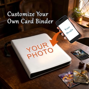 Peut inclure: Un classeur de cartes blanc avec le texte "YOUR PHOTO" en orange. L'image montre également un smartphone avec le texte "Your Design" à l'écran et plusieurs cartes à collectionner. Le texte "Customize Your Own Card Binder" est en haut.