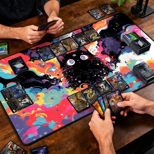May include: A colorful playmat featuring a black cat design with a starry background and vibrant clouds. The mat is covered with trading cards, with two people playing a card game on a wooden table.