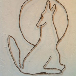 May include: A wire sculpture of a fox sitting in a circle, made from barbed wire.