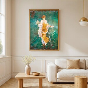 May include: A framed wall art print featuring a classical figure in a flowing yellow and white garment, set against a deep emerald green background. The figure holds a cornucopia and stands amidst delicate white flowers in a vertical composition.