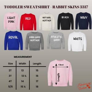 K&ouml;nnte beinhalten: Eine Auswahl an Sweatshirts f&uuml;r Kleinkinder in verschiedenen Farben, darunter Hellrosa, Rot und Marineblau. Das Bild zeigt die Sweatshirts mit dem Text "TODDLER SWEATSHIRT - RABBIT SKINS 3317". Ma&szlig;e sind f&uuml;r die Gr&ouml;&szlig;en 2T bis 5/6 angegeben, mit Breiten von 33 bis 39 cm.