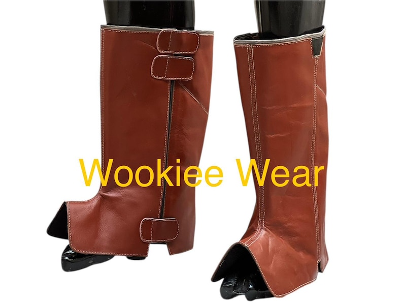 May include: Brown leather boots with white stitching and buckle details. The boots have a unique design with a separate foot covering. The text "Wookiee Wear" is visible on the image.