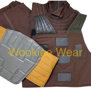 May include: A brown costume with a vest, shoulder pads, and a neck piece. The vest has black patches and the shoulder pads are gray and yellow. The neck piece has a brown and green design. The text "Wookiee Wear" is visible.