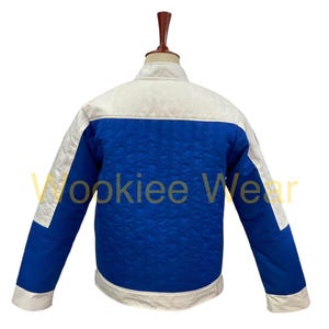 May include: A blue and white jacket with a quilted pattern. The jacket has a white collar, shoulders, and cuffs, with a blue body. The text "Wookiee Wear" is visible on the jacket.