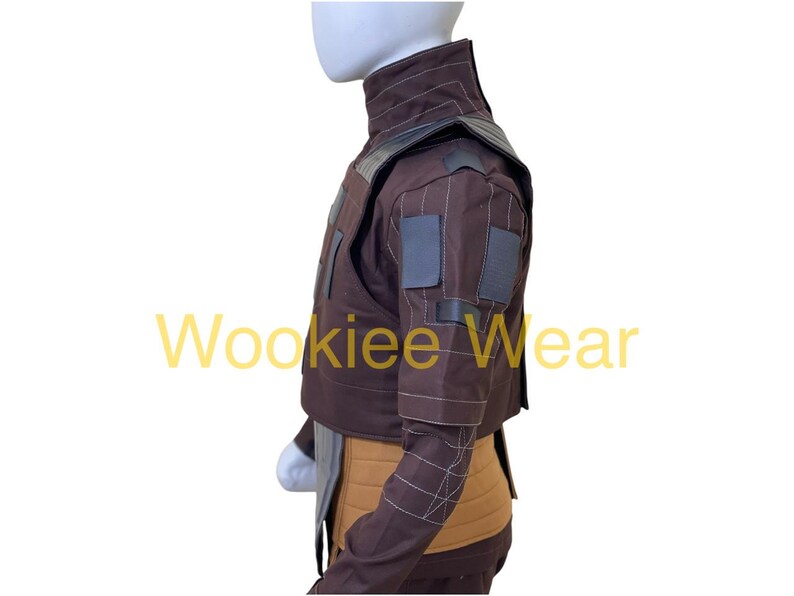 May include: A brown costume jacket with a high collar and gray accents. The jacket has square patches on the sleeves and a tan midsection. The text "Wookiee Wear" is visible in yellow.