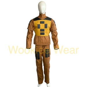 May include: A brown and yellow costume with black accents, displayed on a mannequin. The costume includes a jacket and pants. The jacket has a yellow chest piece with black squares. The pants have black patches on the knees. The text "Wookie Wear" is visible.