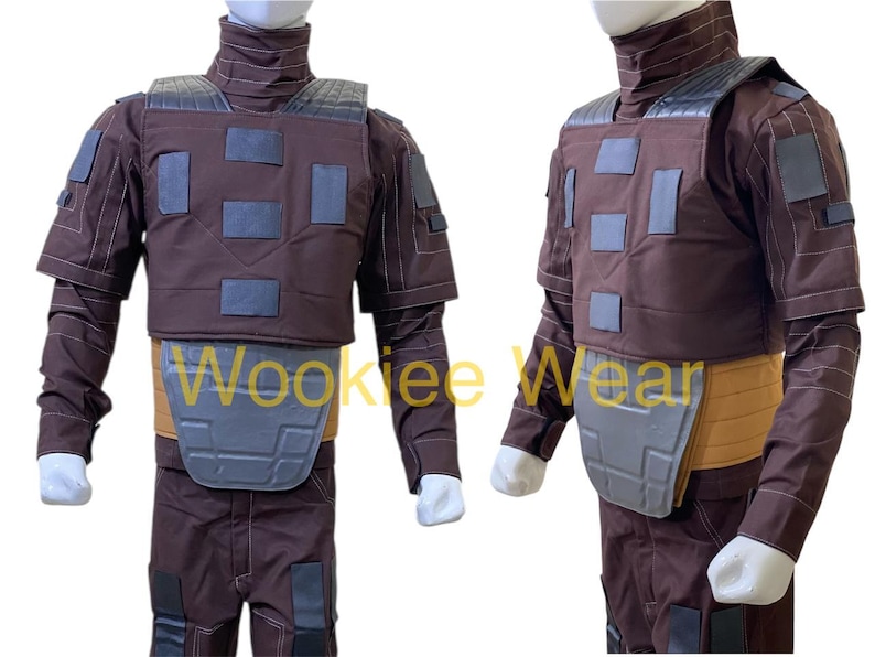 May include: A brown costume with a high collar, shoulder pads, and a chest plate. The costume has a tan belt and gray accents. The sleeves are long and the pants are brown. The costume is displayed on a mannequin.