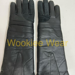 May include: A pair of black leather gloves with long gauntlets. The gloves have a suede patch on the palm and three horizontal lines on the upper arm. The text "Wookiee Wear" is printed on the gloves.