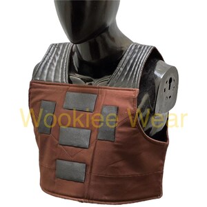 May include: A brown and black costume vest with rectangular black accents. The vest is displayed on a black mannequin. The text "Wookiee Wear" is visible in the image.