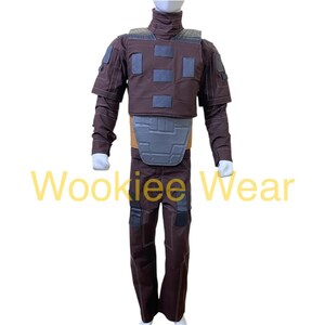 May include: A brown costume with a high collar, shoulder pads, and a chest plate. The costume includes matching pants and is displayed on a white background. The text "Wookiee Wear" is visible.