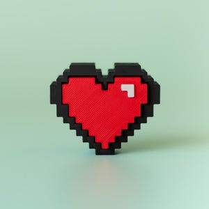 Könnte beinhalten: Ein pixeliges Herz in Rot und Schwarz mit einem kleinen weißen Quadrat auf der rechten Seite. Vor einem hellgrünen Hintergrund erzeugt das Bild eine Retro- und Digitalästhetik. Das Design erinnert an klassische Videospielgrafiken.