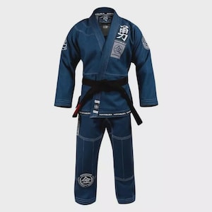 Puede incluir: Un uniforme de artes marciales azul, que consta de una chaqueta y pantalones, con un cinturón negro. El uniforme tiene costuras blancas y parches con caracteres y logotipos japoneses. La chaqueta tiene solapas y los pantalones tienen cordón.
