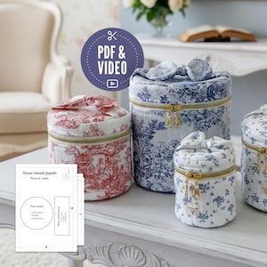 Può includere: Una collezione di custodie rotonde in tessuto trapuntato con cerniere dorate e cime a forma di fiocco. Le custodie presentano vari motivi, tra cui un design toile rosso e bianco e stampe floreali blu. L'immagine include un'icona PDF e video e un modello di cucito.