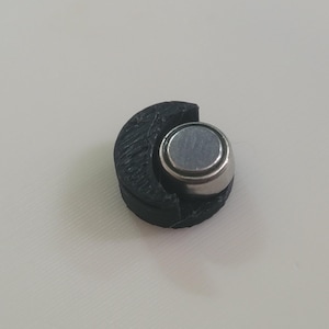 May include: A white ceramic mug with a black handle and the text "But First, Coffee" in a bold, black font. The mug is set against a neutral background, highlighting its simple design.