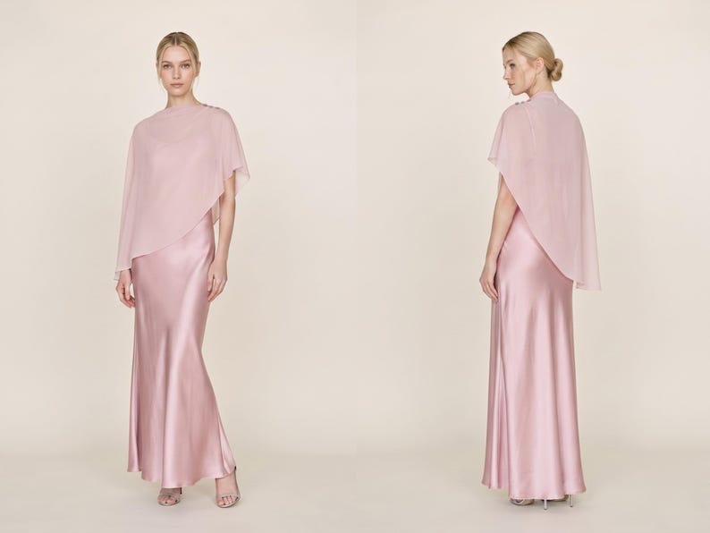 This elegant pastel pink silk gown with a detachable sheer cape offers a chic and refined silhouette, ideal for bridesmaids, wedding guests, or as a thoughtful bridal gift. Featuring a cowl neckline and asymmetrical cape hem, this dress creates a graceful look for any formal event. Whether for a wedding or bridal celebration, this dress is a beautiful and luxurious gift option for someone special.