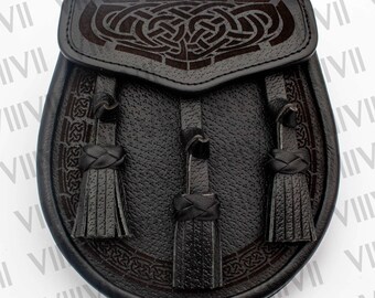 May include: A black leather sporran featuring a textured surface and a flap adorned with an intricate embossed Celtic knotwork pattern. The front of the pouch includes three hanging leather tassels with braided details, providing a structured design.