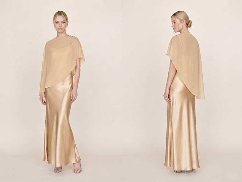 This light silver silk gown with a detachable sheer cape offers a stunning, elegant silhouette perfect for weddings or other formal events. With its soft cowl neckline and asymmetrical hemline, this dress flows gracefully with every movement. Ideal as a wedding gift or bridesmaid dress, it brings a refined and fashionable touch to any bridal celebration, making it a great gift for those looking to celebrate with a luxurious, timeless style.