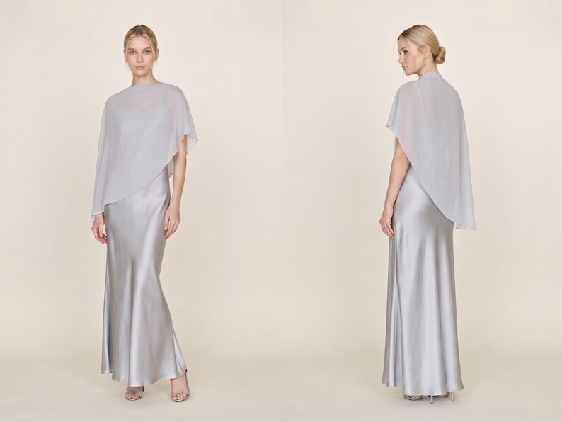 This stunning satin ivory silk dress with a detachable sheer cape is designed to make an impact at any bridal event. The cowl neckline and asymmetrical hemline create a graceful, flowing silhouette that flatters the figure beautifully. Ideal as a bridal party gift, this dress adds a touch of elegance to wedding celebrations and makes for a thoughtful gift for bridesmaids or wedding guests looking for a classic yet luxurious style.