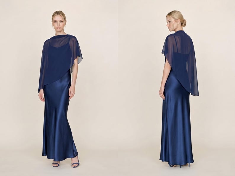 This beautiful navy silk maxi dress with a detachable sheer cape brings a touch of sophistication to any wedding or formal event. Featuring a cowl neckline and asymmetrical hem, it creates a striking and graceful silhouette. A perfect bridal party gift or wedding guest outfit, this dress combines classic elegance with contemporary design, making it an ideal choice for bridesmaids or for giving a loved one a thoughtful, stylish bridal gift.