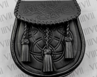 May include: A black leather sporran featuring an embossed Celtic knot design on the front flap and body. The accessory includes three braided leather tassels hanging from the flap, with whip-stitched edges along the top closure and perimeter.