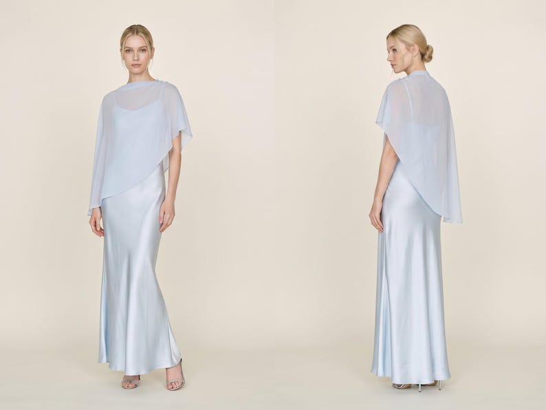 This beautiful pastel blue silk gown with a detachable sheer cape offers a graceful, elegant look perfect for wedding events or bridal celebrations. The cowl neckline and asymmetrical cape hem bring a refined and chic silhouette, making it an ideal choice for bridesmaids, wedding guests, or as a bridal shower gift. This dress radiates sophisticated style, making it an unforgettable addition to any bridal event or formal gathering.