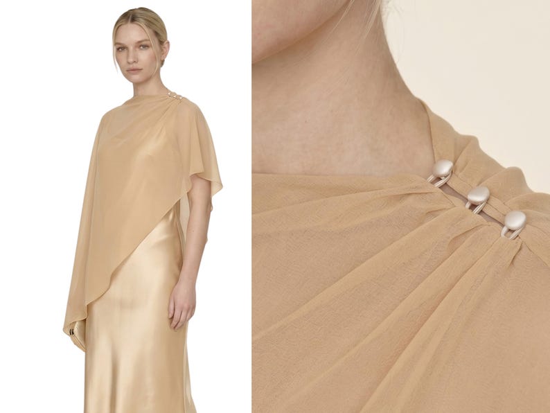 This stunning soft champagne silk dress with a detachable sheer cape combines elegance with a contemporary edge, perfect for a wedding or bridal event. The cowl neckline and asymmetrical cape hem add movement and grace, making it a fantastic option for bridesmaids, wedding guests, or as a luxurious bridal shower gift. It’s ideal for gifting during bridal celebrations, offering a polished yet understated way to celebrate the occasion.