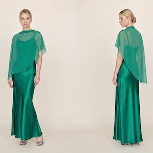 This luxurious emerald green silk maxi dress with a detachable sheer cape exudes elegance and timeless beauty, ideal for wedding guests, bridesmaids, or even as a thoughtful bridal shower gift. The cowl neckline and asymmetrical cape hem create an elegant movement that is both striking and graceful. It’s perfect for formal events, creating a chic and sophisticated bridal look, and serves as a refined gift for those celebrating love and commitment.