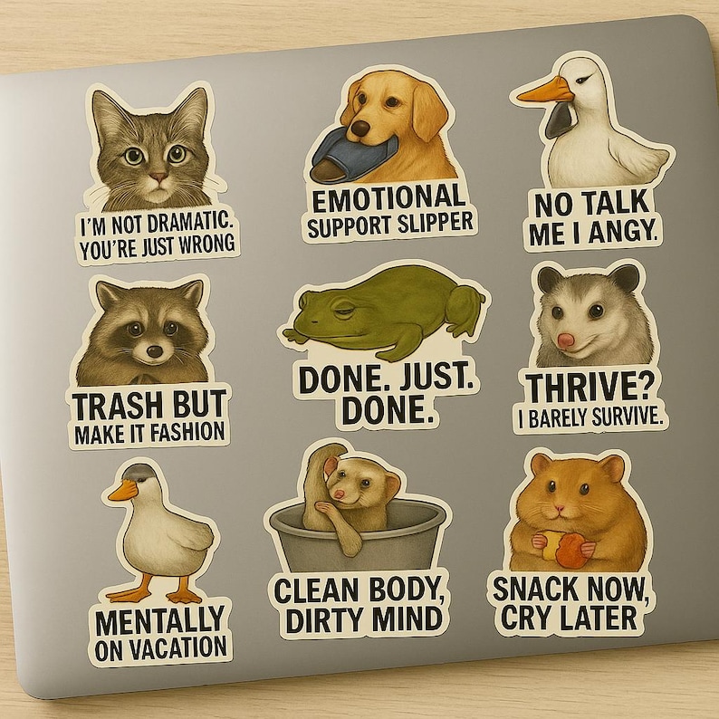 May include: A collection of humorous stickers featuring various animals. The stickers include a cat, dog, raccoon, frog, duck, meerkat, possum, and hamster, each with a unique phrase. The stickers are designed with a cartoon style and are on a laptop.