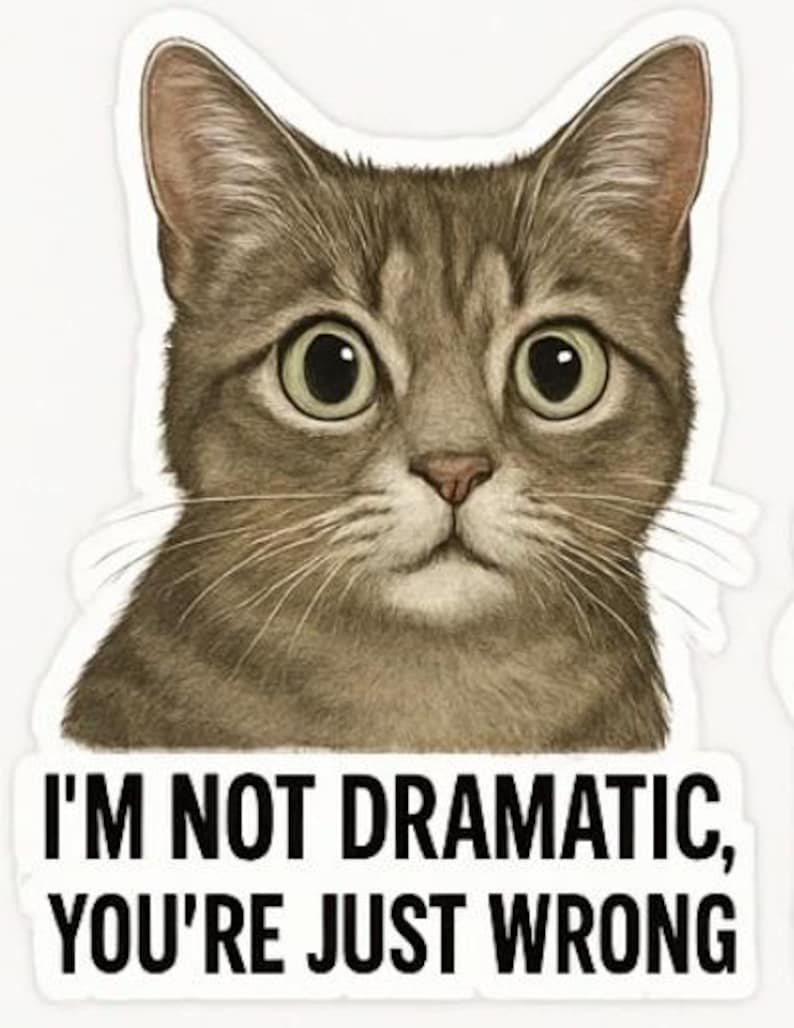 May include: A sticker featuring a detailed illustration of a cat's face with large, expressive eyes. The cat is a mix of brown and gray tones. Below the cat is the text: "I'M NOT DRAMATIC, YOU'RE JUST WRONG."