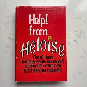 May include: A red book titled "Help! from Heloise." The cover features white text and a yellow flower graphic. The book is a household companion volume to "Hints from Heloise."