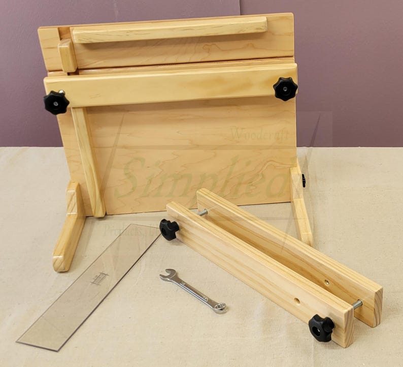 May include: A wooden easel with adjustable height and angle. The easel is made of natural wood and has a simple design. It comes with a wrench for assembly and a clear ruler.