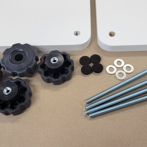 May include: A set of four black knobs, four silver washers, four black felt pads, and four silver screws with a silver head. The screws are approximately 6 inches long.