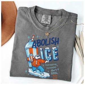 May include: Gray Comfort Colors t-shirt with the words "Abolish ICE" and a cartoon polar bear holding a drink. The shirt also has the text "Kidnapping HUMANS ISN'T COOL. It's evil."