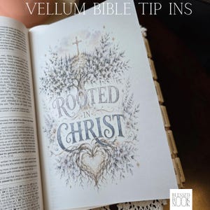 May include: A vellum bible tip-in page featuring a detailed illustration of a tree with a cross at the top and a heart-shaped root system at the bottom. The text ROOTED IN CHRIST is centered in the middle. The page includes decorative floral elements.