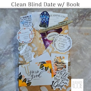 May include: A wrapped book gift set featuring a cross-shaped paperclip, a pen with text, a Twinings tea bag, and multiple stickers with religious quotes including By Grace, The Lord is My Shield, and He is Good, all arranged on a floral paper.